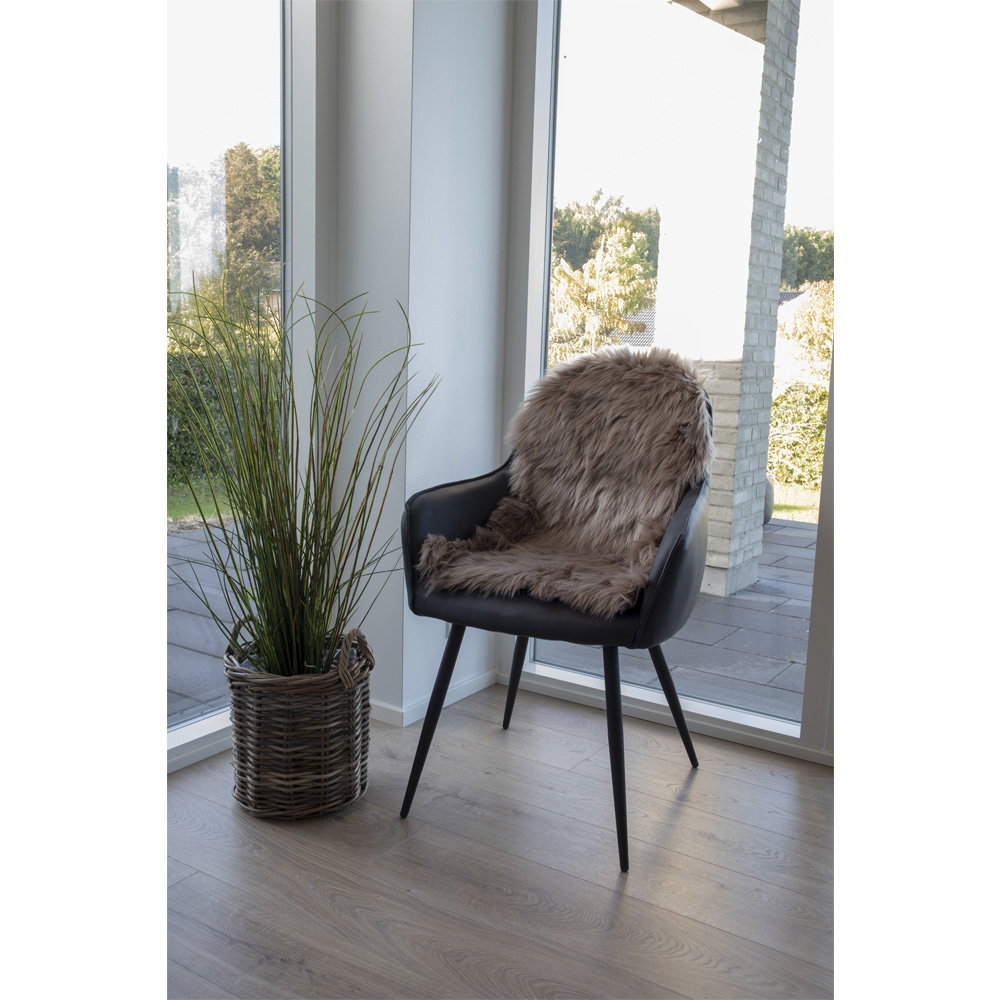 Fausse fourrure mushroom posée sur fauteuil noir cuir ambiance nordique lumineuse