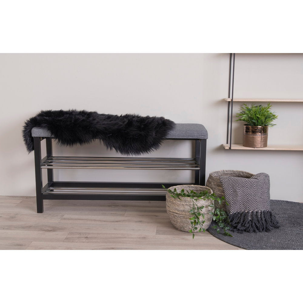 Fausse peau d'agneau noire drapée sur banc d'entrée noir ambiance scandinave épurée