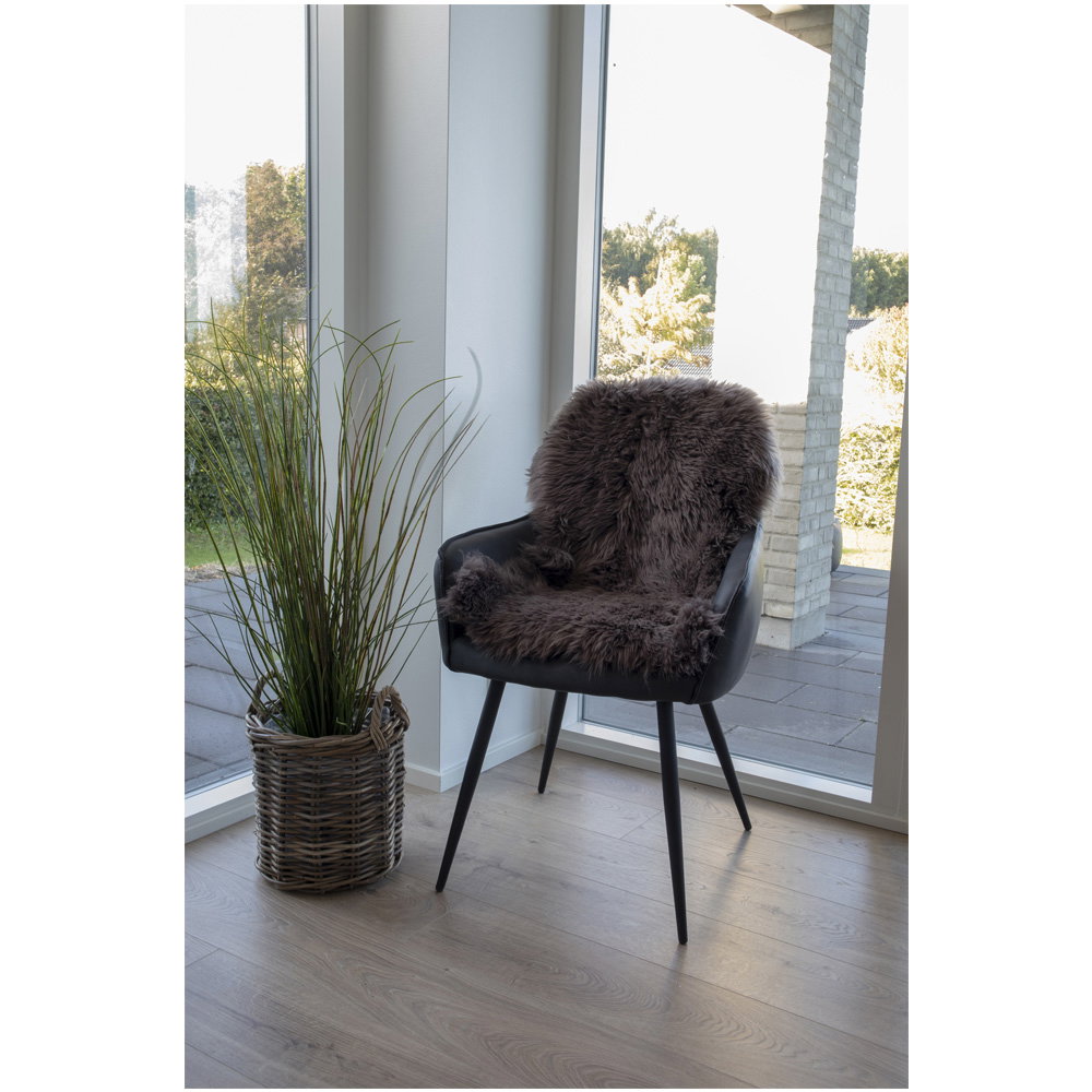 Vraie peau d'agneau brune drapée sur fauteuil noir cuir ambiance scandinave lumineuse