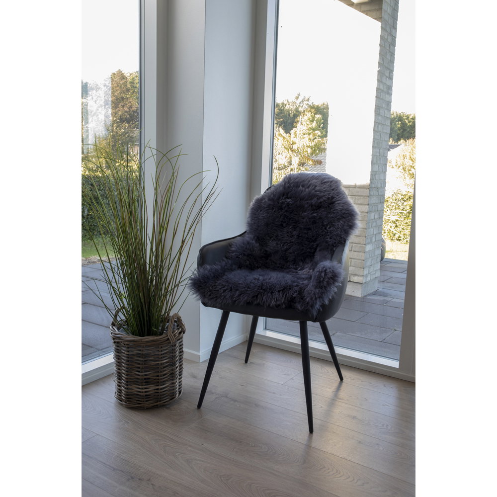 Vraie peau d'agneau grise drapée sur fauteuil noir cuir ambiance scandinave lumineuse