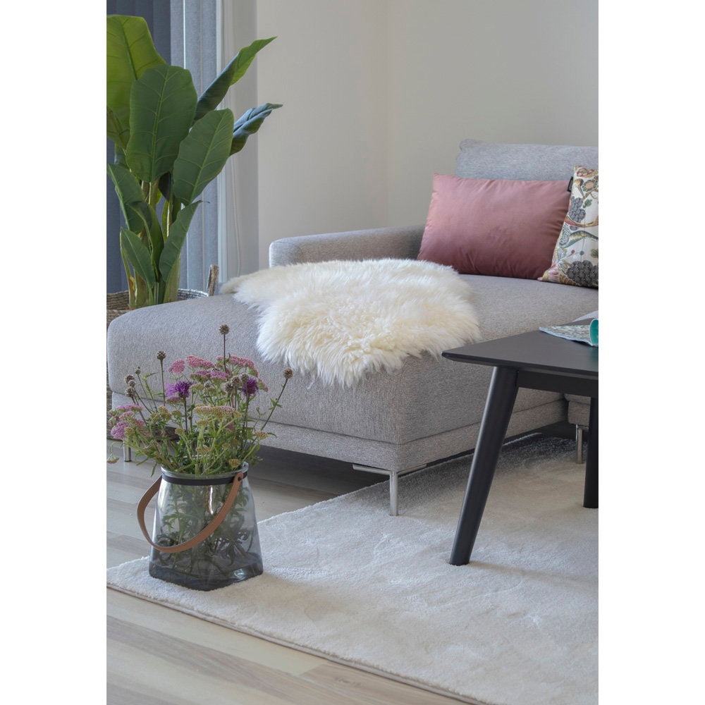 Vraie peau d'agneau ivoire drapée sur méridienne canapé gris salon scandinave lumineux