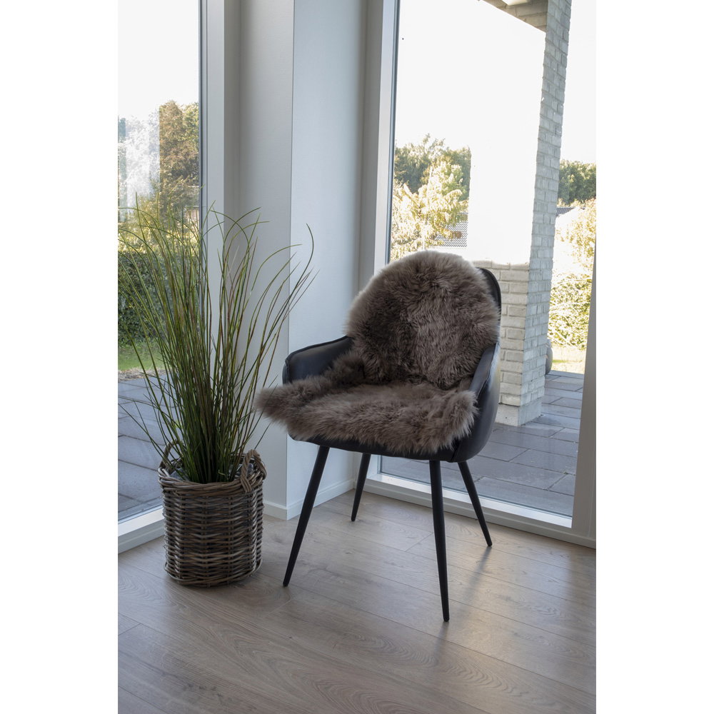 Vraie peau d'agneau mushroom drapée sur fauteuil noir cuir ambiance scandinave lumineuse