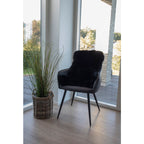 Vraie peau d'agneau noire drapée sur fauteuil noir cuir ambiance scandinave lumineuse