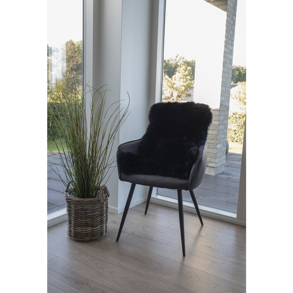 Vraie peau d'agneau noire drapée sur fauteuil noir cuir ambiance scandinave lumineuse
