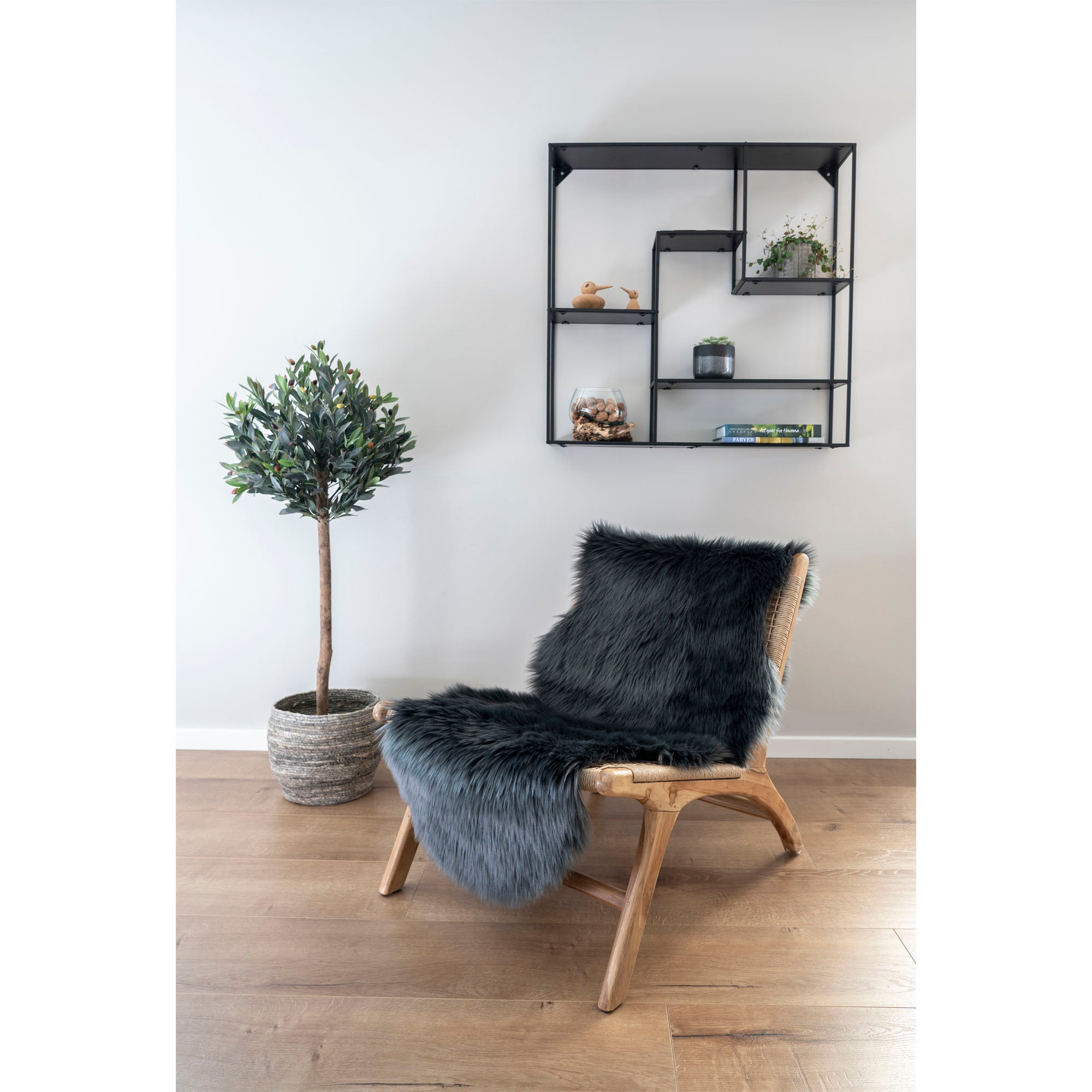 Peau d'agneau synthétique gris anthracite posée fauteuil rotin salon parquet