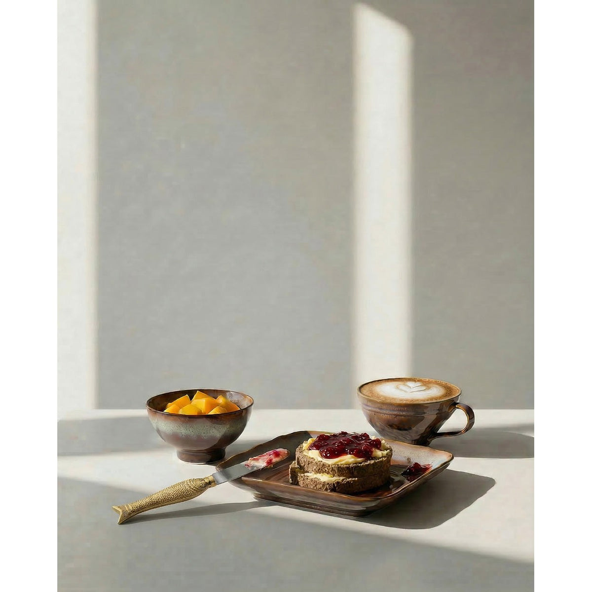Petit bol Smoked Horizon rempli de mangue près d'une tasse et d'une assiette carrée de la même collection