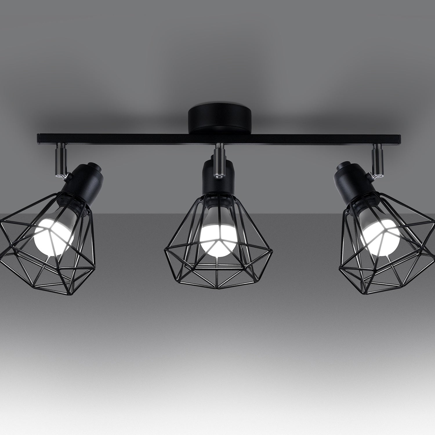 Plafonnier Artemis 3 noir allumé, ombres géométriques des cages