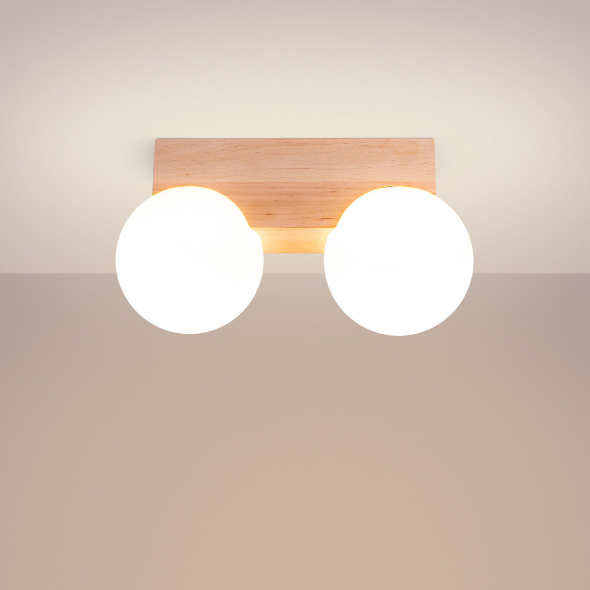 Plafonnier Bulbo 2 allumé avec ses deux globes opale lumineux sous un plafond beige