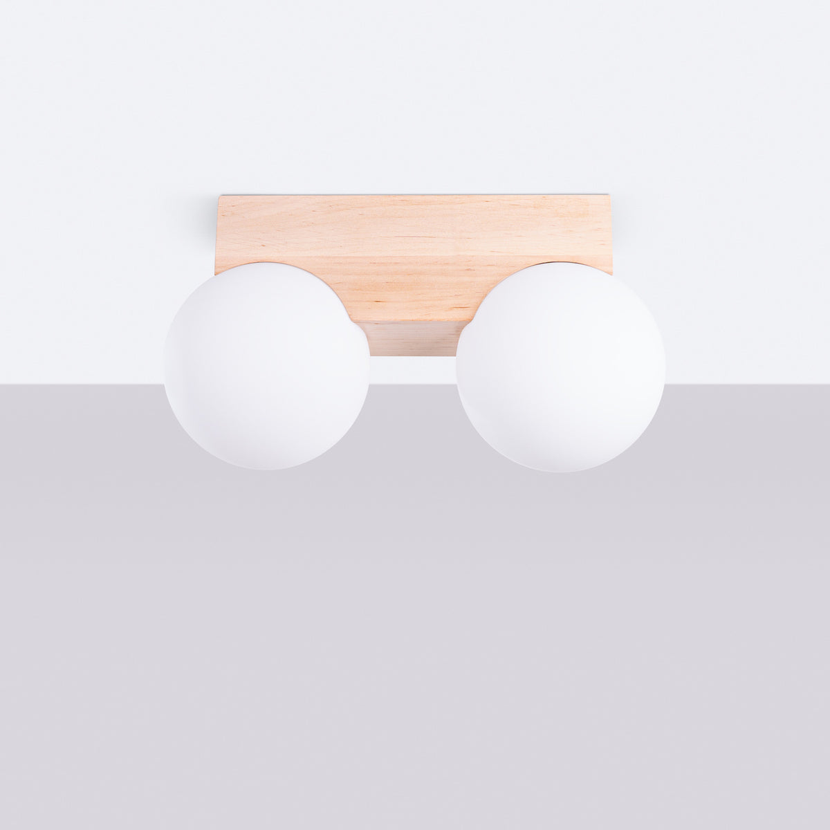 Plafonnier Bulbo 2 en bois naturel et verre opale fixé à un plafond blanc