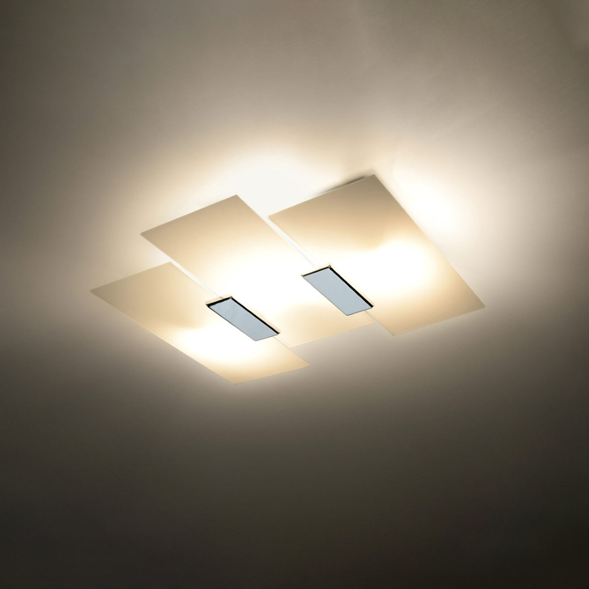 Plafonnier Fabiano allumé avec un halo de lumière autour de ses panneaux de verre