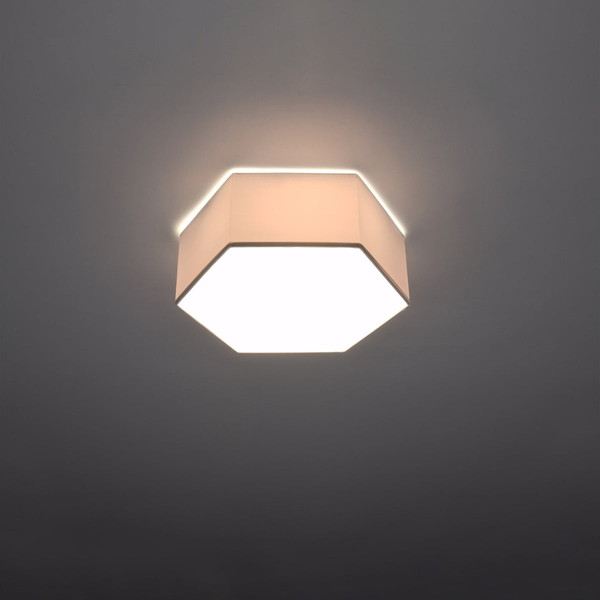 Plafonnier Sunde PVC blanc hauteur 115 mm allumé avec son diffuseur éclairé et un léger halo au plafond