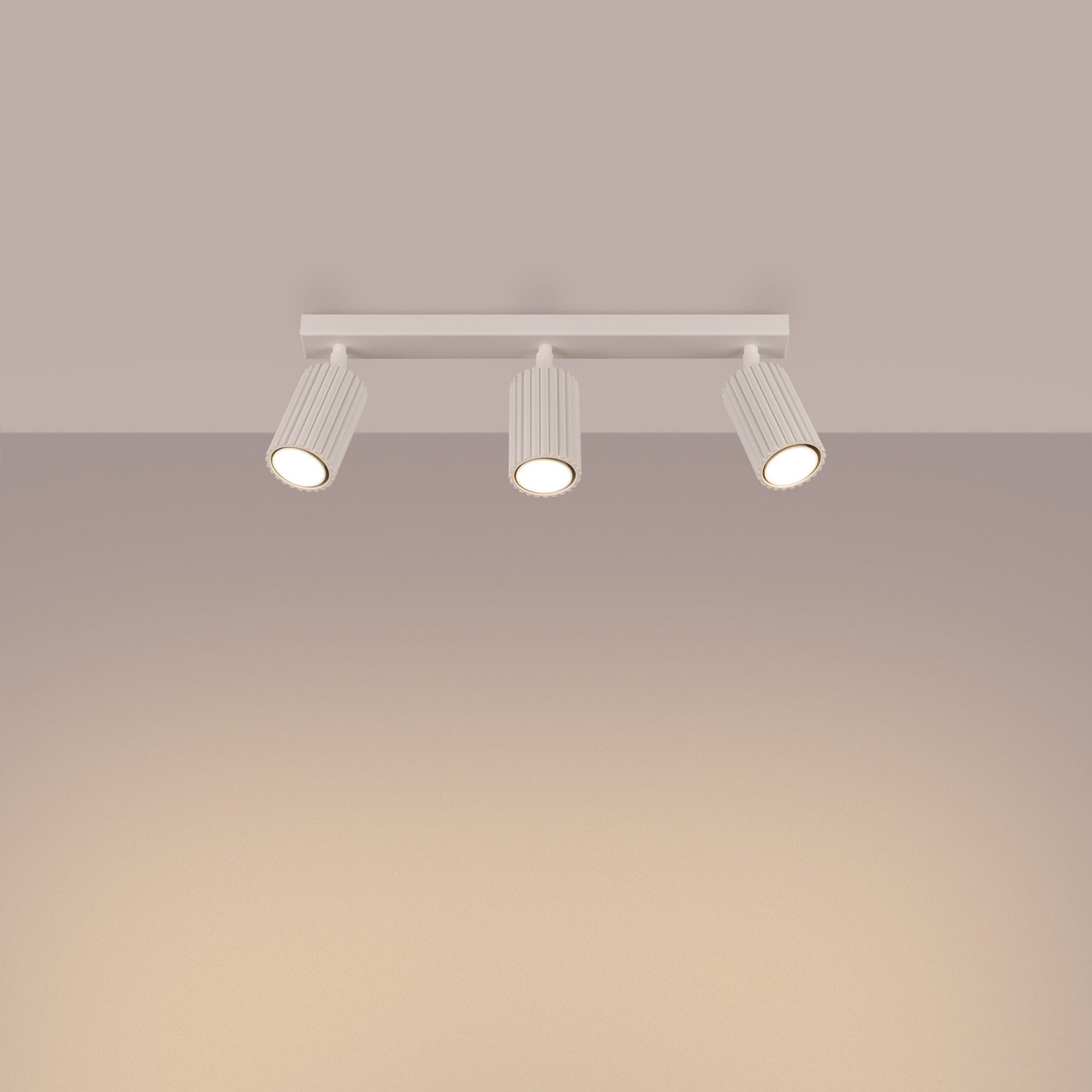 Plafonnier Karbon 3 spots barre beige allumé, trois faisceaux orientés