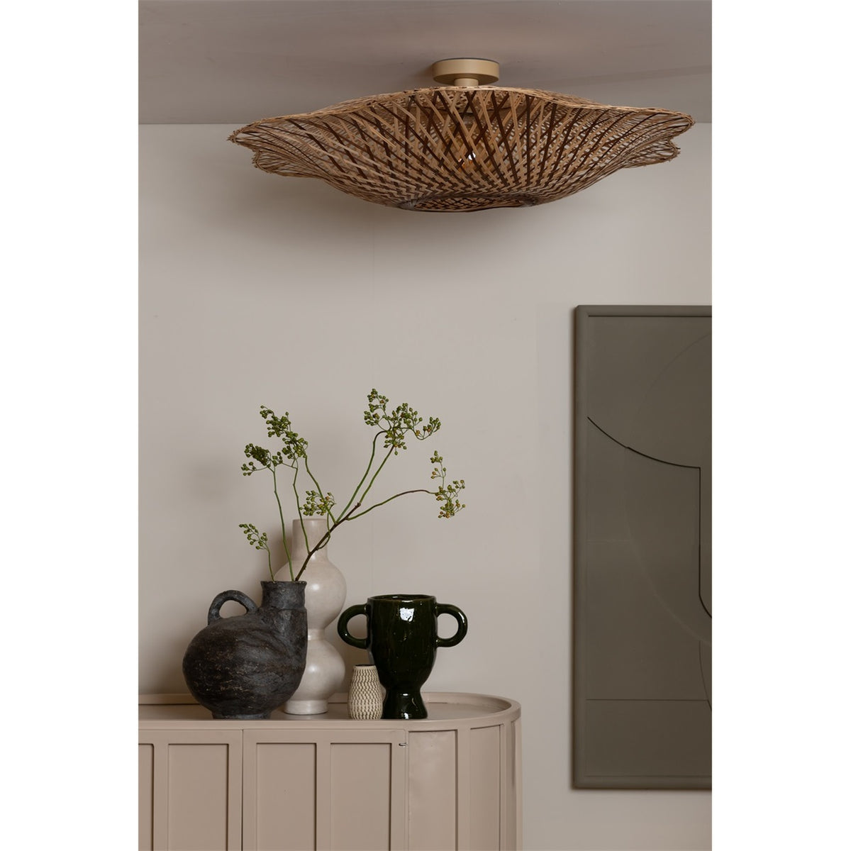 Plafonnier Madura au-dessus d'un buffet beige garni de vases et de branchages