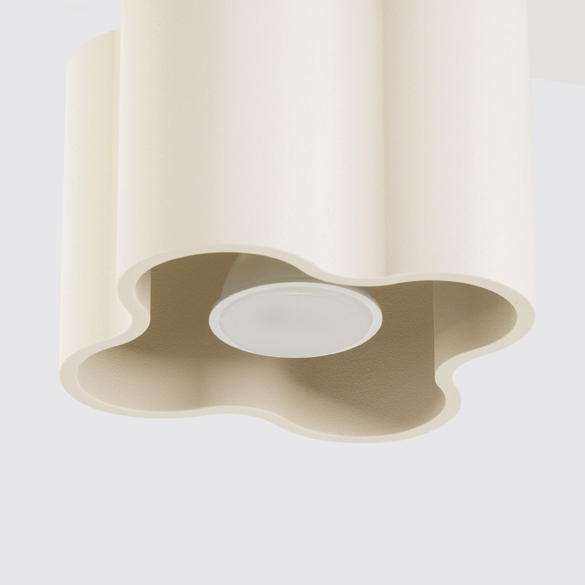 Plafonnier Ovio laque beige vu de dessous avec son ouverture à quatre lobes et l’ampoule GU10