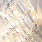 Détail des prismes de verre du plafonnier Puccini éclairés et de leurs attaches métalliques