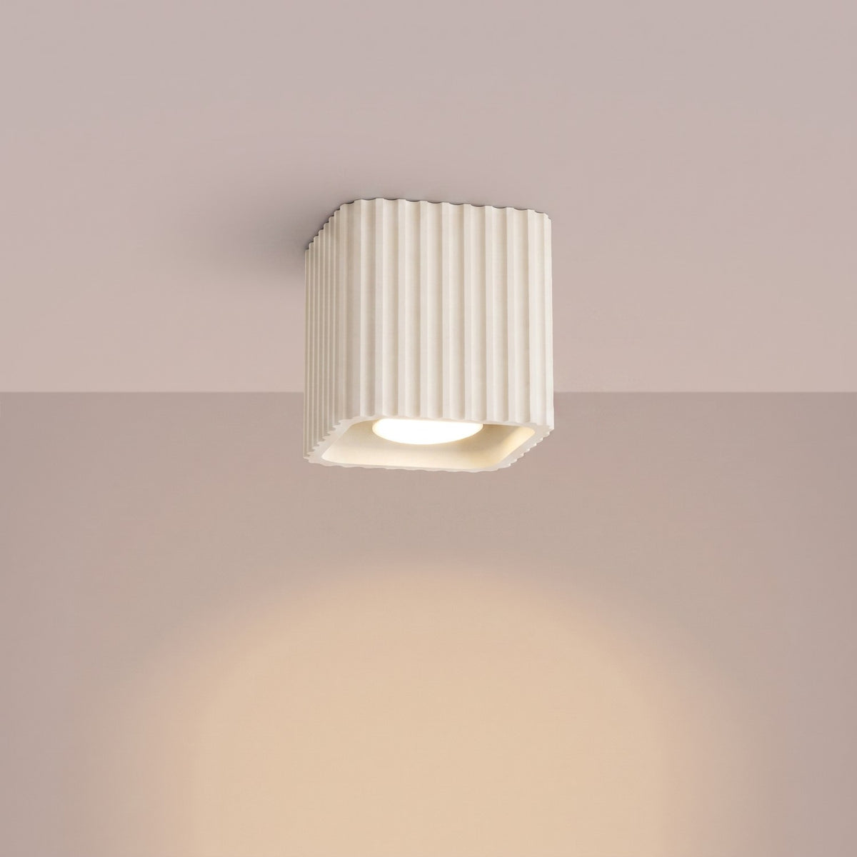 Plafonnier Riff laque beige allumé au plafond qui éclaire vers le bas