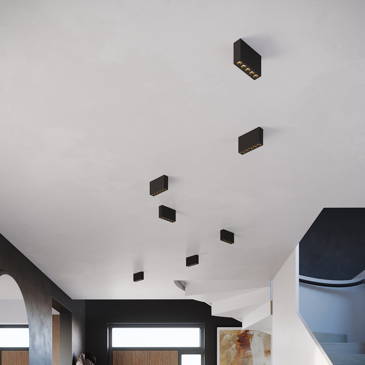 Plafonniers Sole noirs disposés en quinconce au plafond d'un hall avec escalier