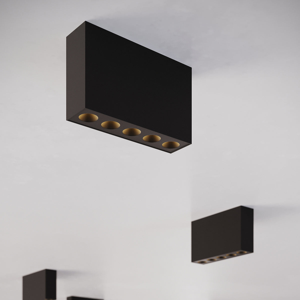 Trois plafonniers Sole noirs répartis sur un plafond blanc