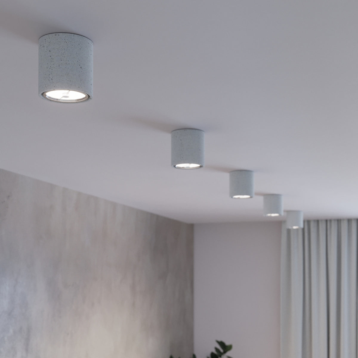 Plafonniers Cullo béton gris allumés alignés le long d'un plafond blanc