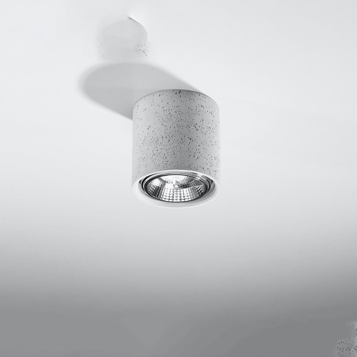 Plafonnier Cullo béton gris fixé à un plafond blanc et son ombre portée