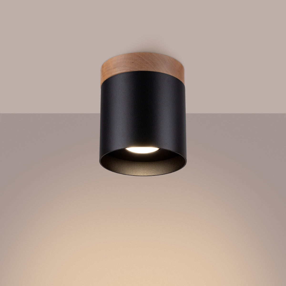 Plafonnier Rif en métal noir allumé au plafond avec sa lumière dirigée vers le bas