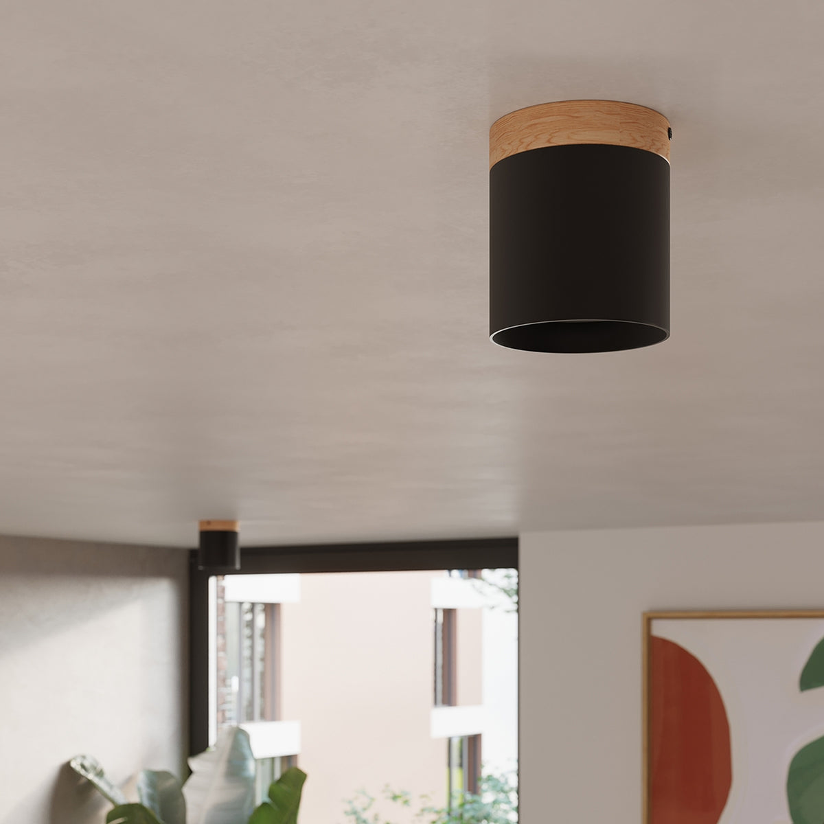 Gros plan du plafonnier Rif en métal noir fixé au plafond d'un salon avec sa bague en bois veiné