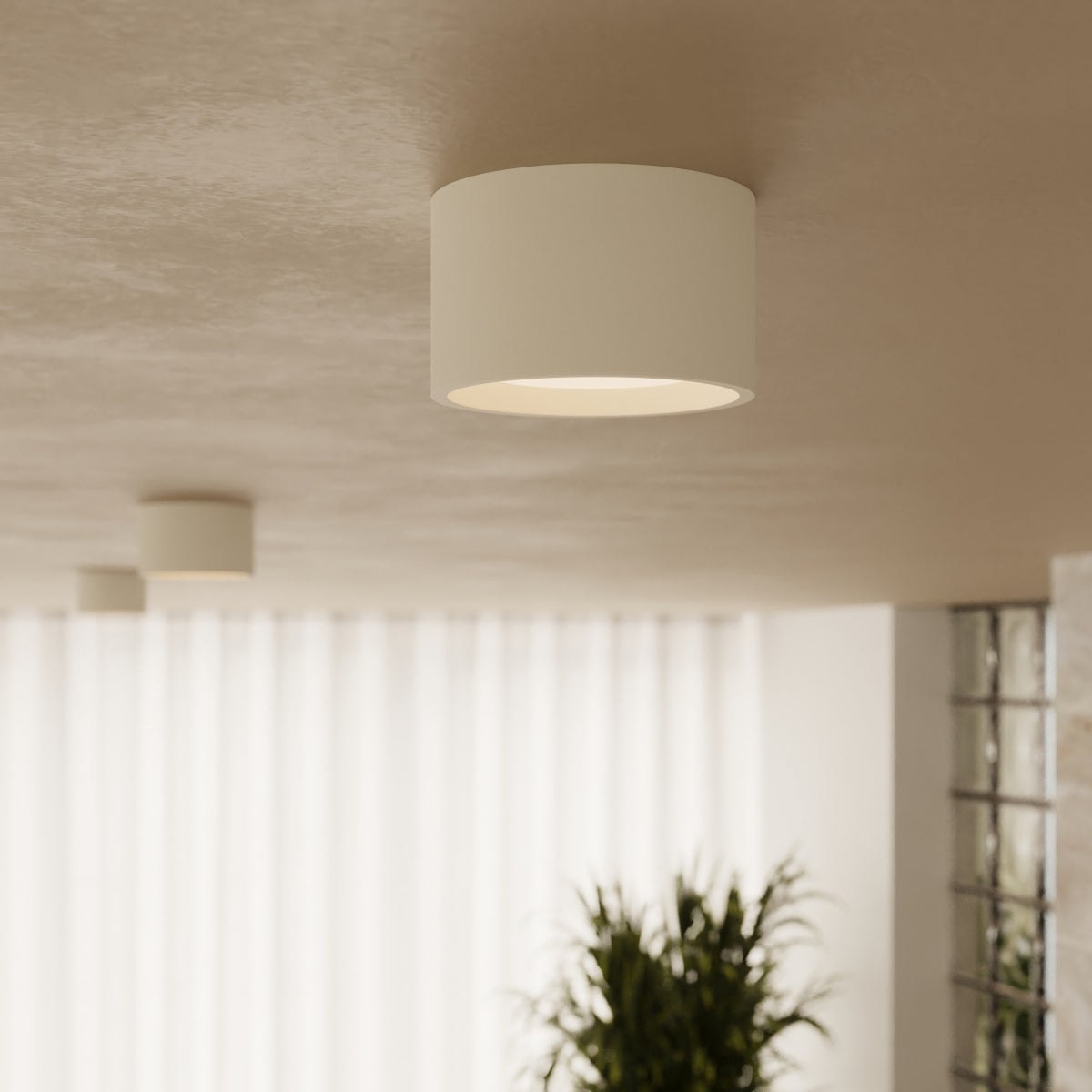 Plafonnier Modo 1 laque beige allumé au plafond en vue rapprochée dans une pièce