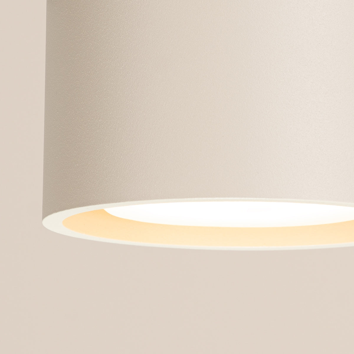 Vue rapprochée du plafonnier Modo 1 laque beige allumé et de sa source en retrait