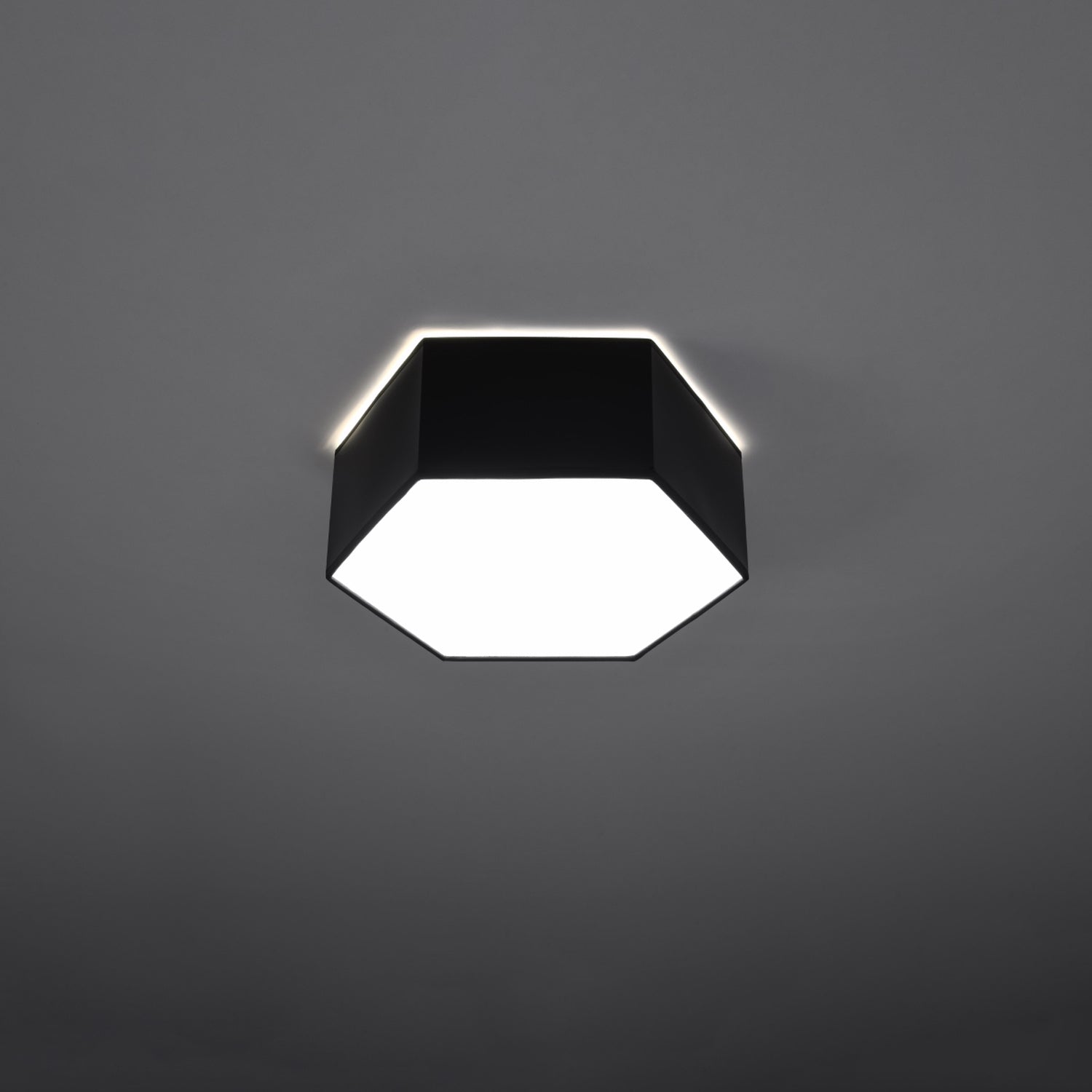 Plafonnier Sunde 11 noir allumé, lumière diffuse vers le bas et halo au plafond