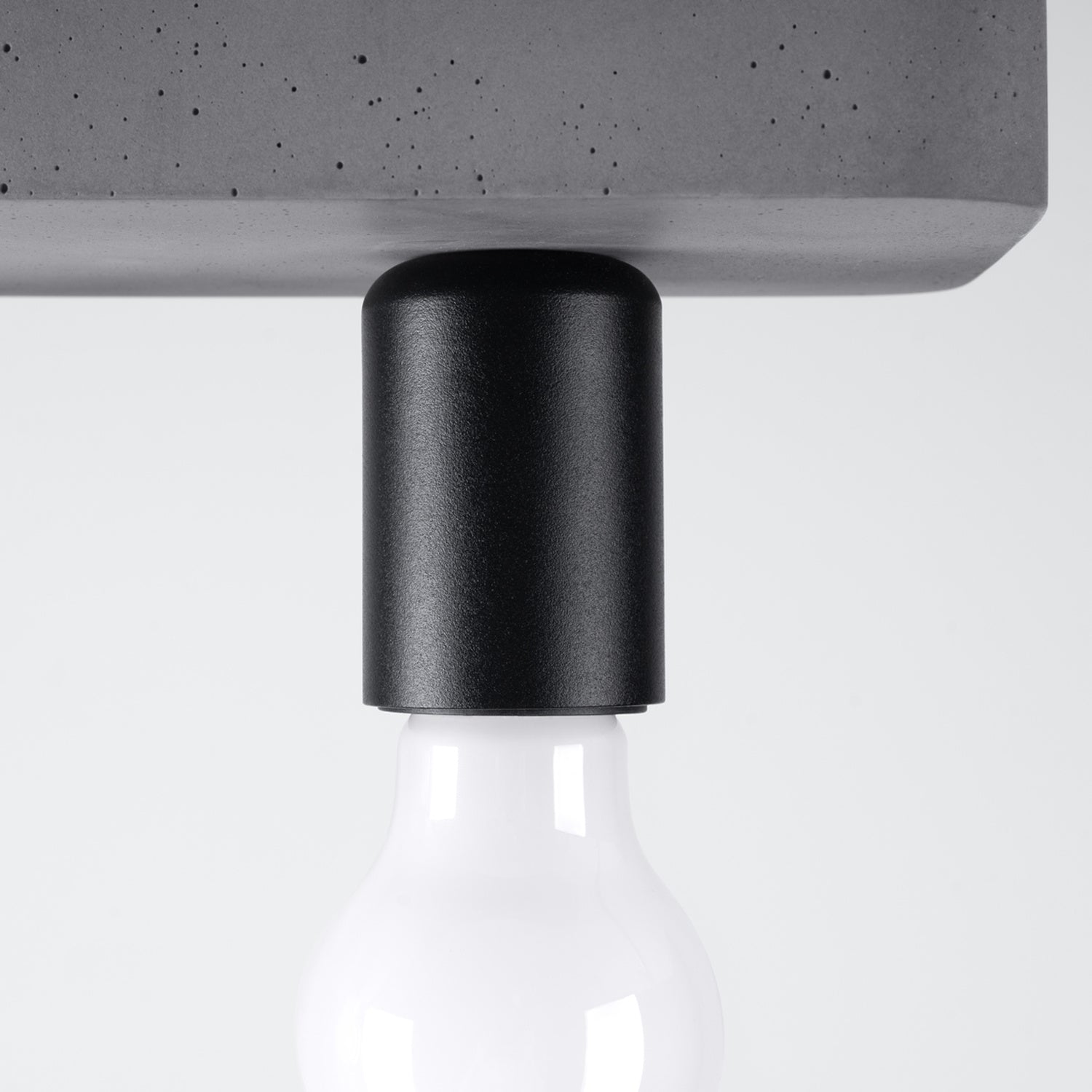 Plafonnier Tavo 3 béton E27, détail d'une douille noire et de l'ampoule