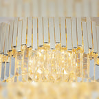 Détail des barrettes en métal doré brillant et des prismes de verre taillés du plafonnier Trend allumé