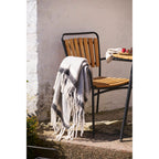 Plaid Carmel laine gris blanc franges longues posé chaise teck métal noir terrasse