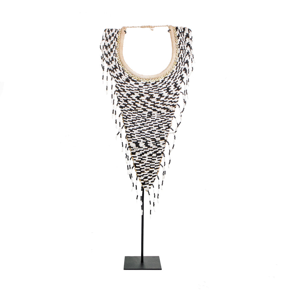 Plastron décoratif perlé noir et blanc à franges monté sur son socle en fer noir vu de face