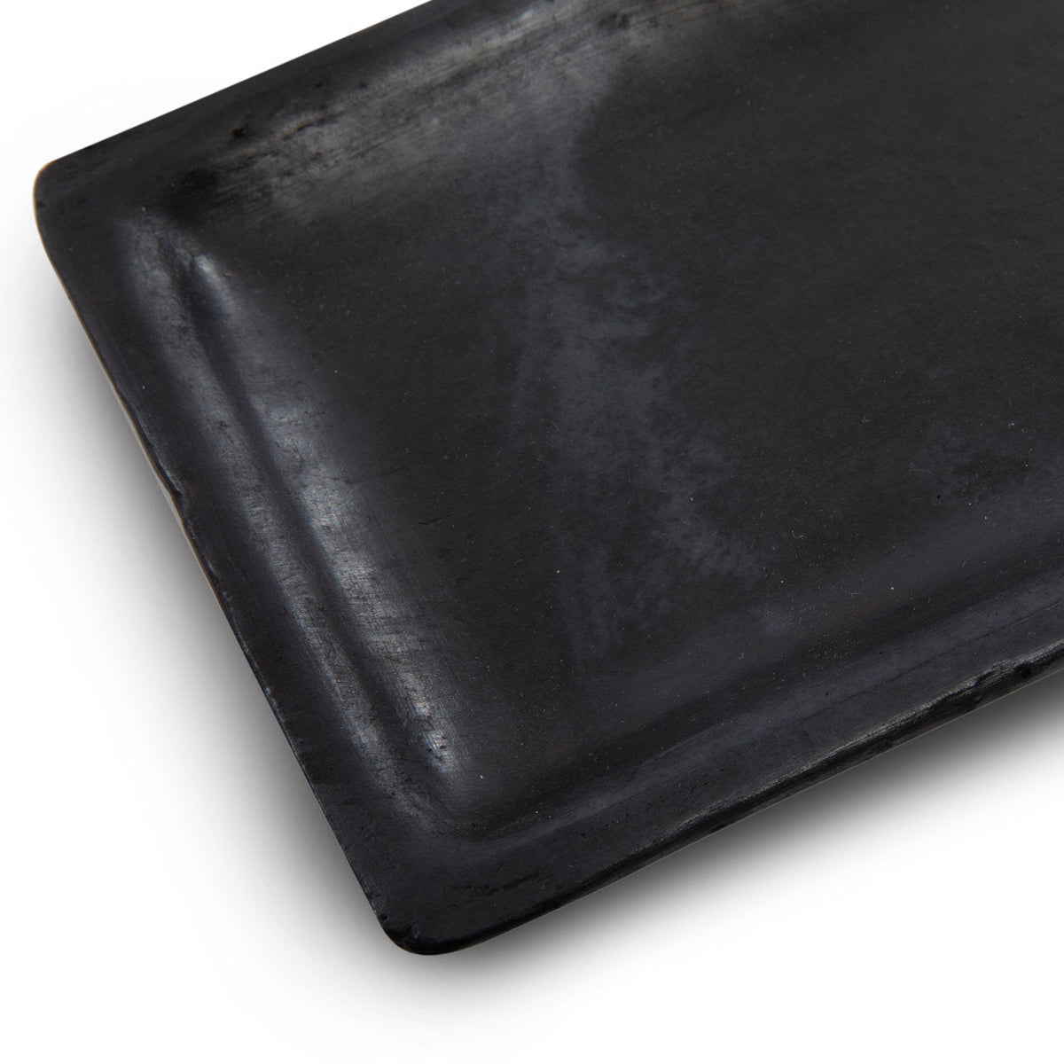 Gros plan sur l'angle arrondi et le bord relevé du plat à sushis 25 x 12 cm aux nuances grises