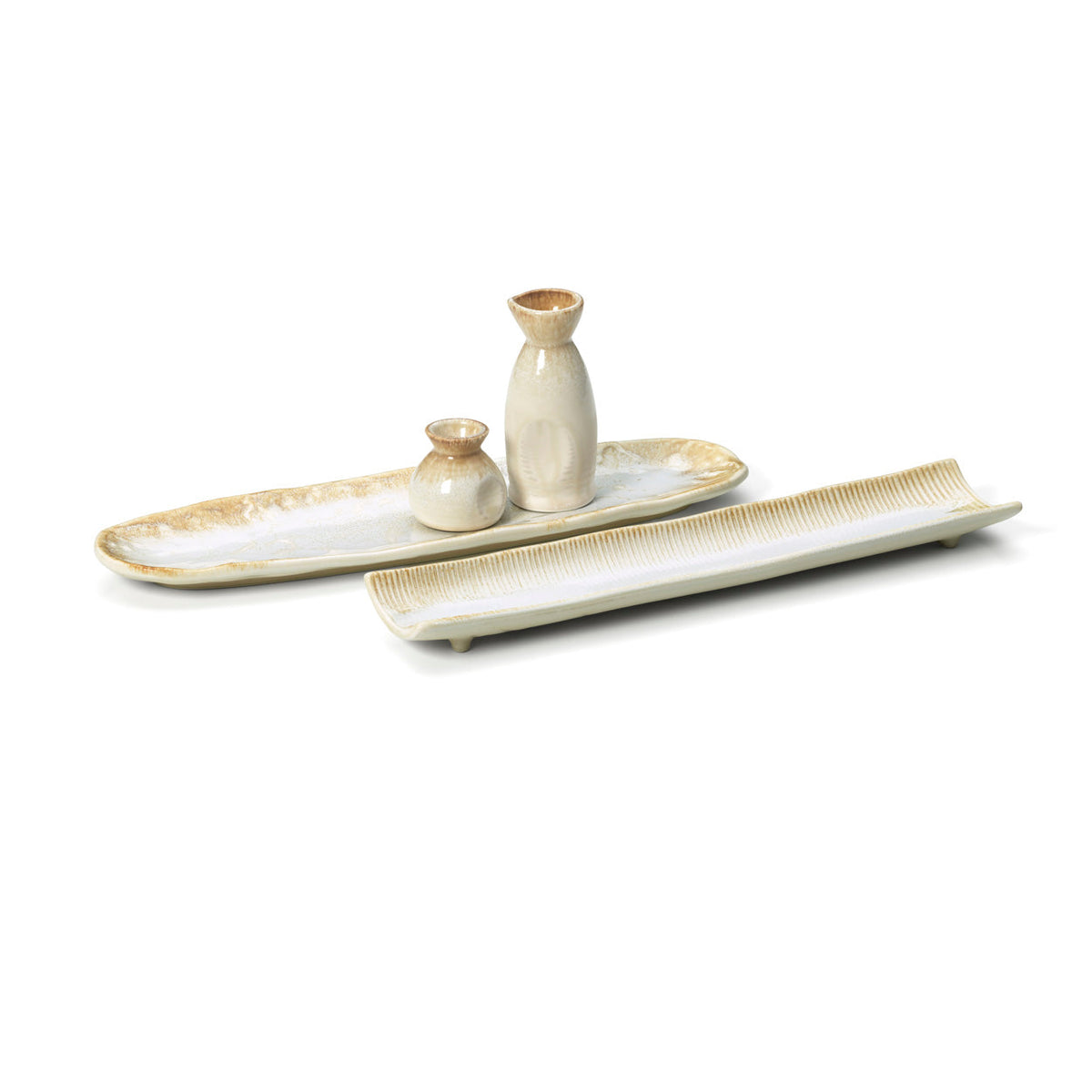 Plat long Da Rocha cannelé à côté d'un plat ovale émaillé portant une carafe à saké et un petit pot émaillé