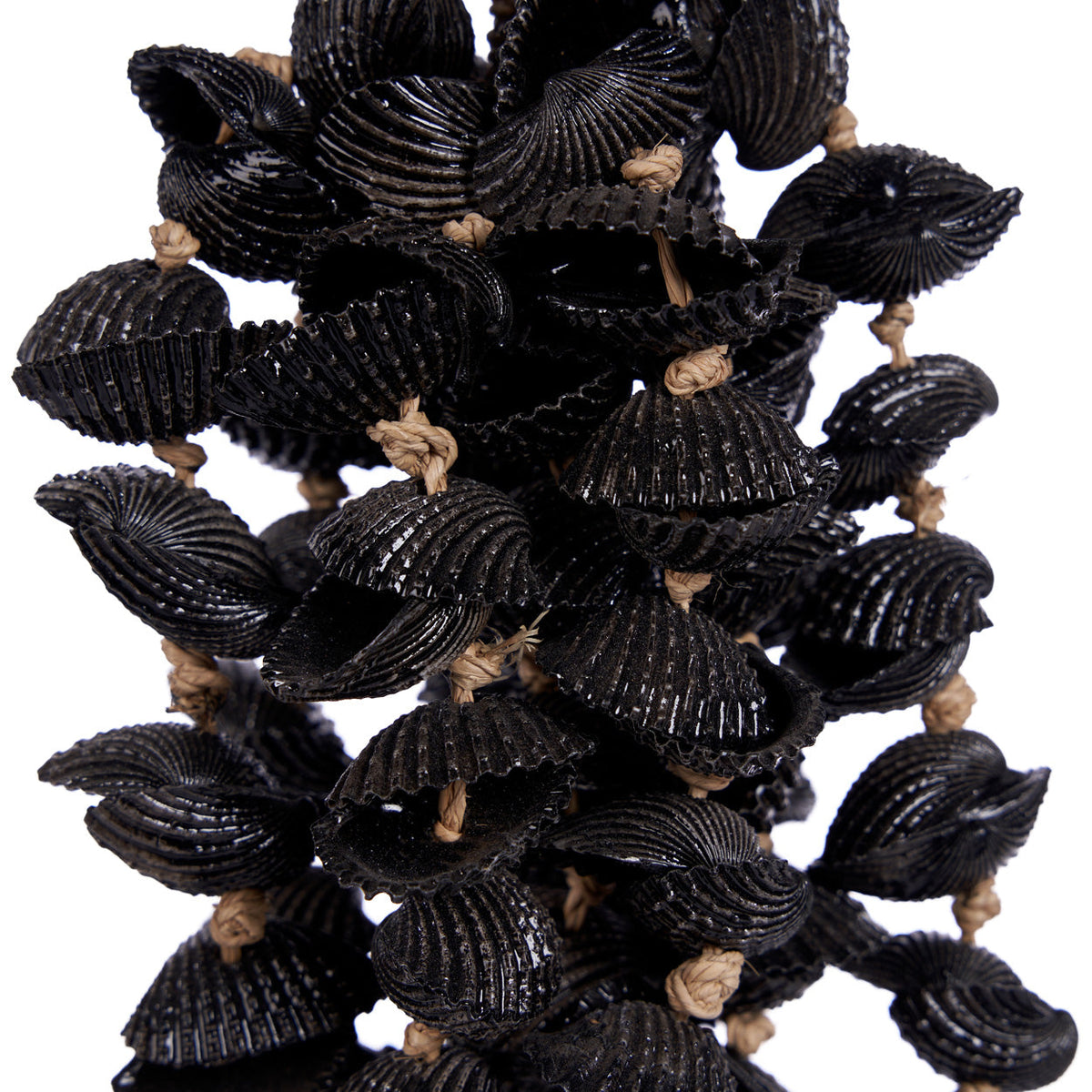 Gros plan sur les coquillages noirs striés et les nœuds de jonc de mer du pompon Midnight