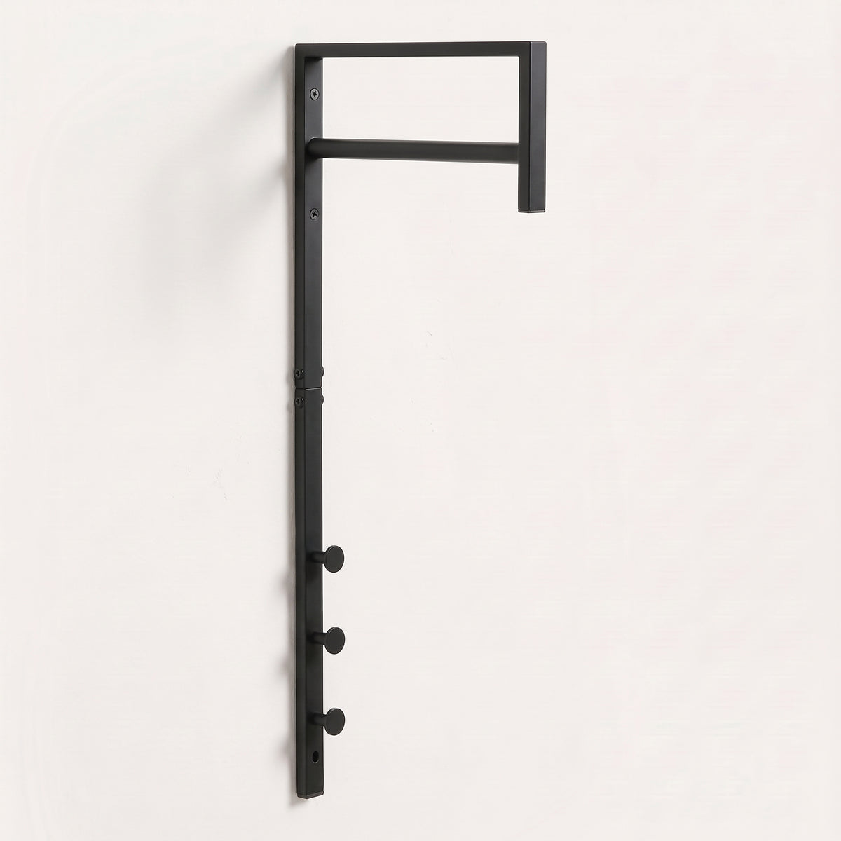 Porte-manteau mural Trento en métal noir mat, avec sa barre de penderie et ses trois crochets ronds
