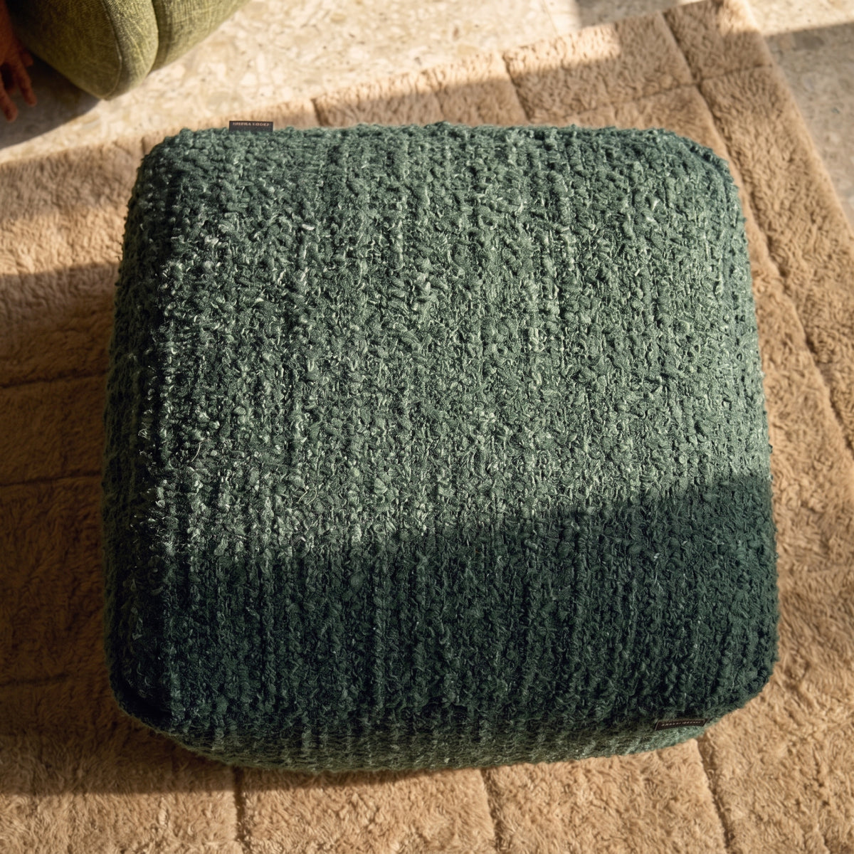 Dessus en coton tissé vert forêt du pouf carré Oh My Gee, vu d'en haut sur un tapis beige