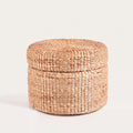 Pouf coffre rond en jacinthe d'eau naturelle tressée, couvercle fermé, vu de face sur fond blanc
