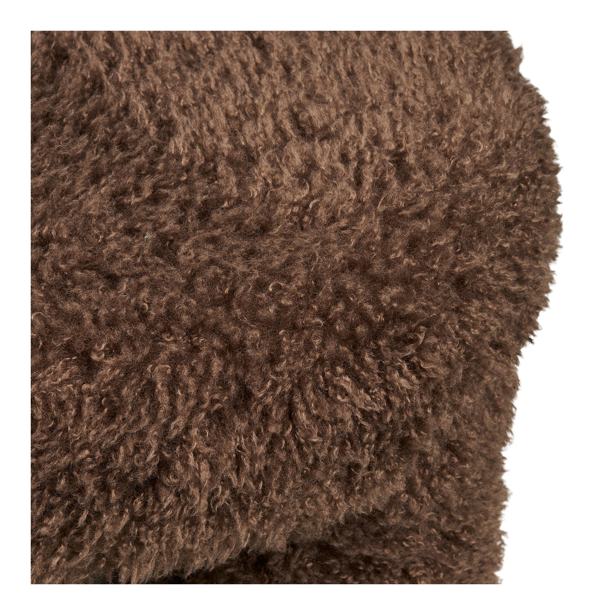 Gros plan sur les poils frisés de la fausse fourrure brune du pouf Gisborne