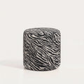 Pouf cylindrique en jacquard zébré noir et blanc cassé sur fond blanc