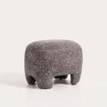 Pouf Nazare en tissu gris chiné vu de trois quarts sur fond clair, assise arrondie sur quatre pieds courts