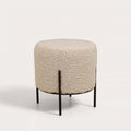 Pouf rond Alford en bouclette crème sur pieds en acier noir, vu de trois quarts sur fond blanc