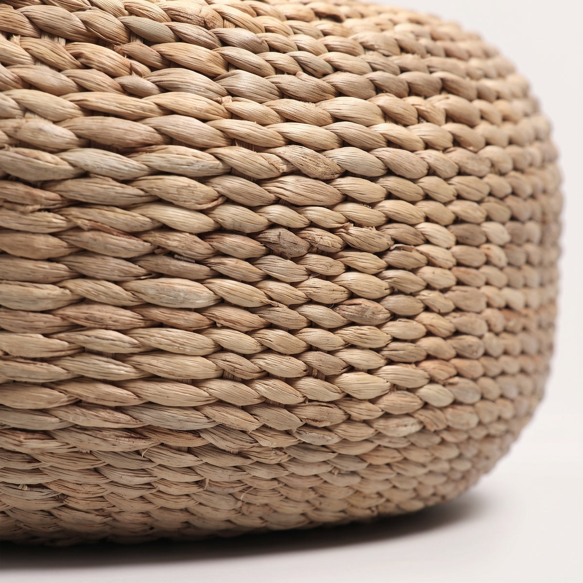 Gros plan sur le tressage torsadé en jacinthe d'eau naturelle du pouf rond
