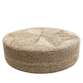 Pouf rond en jonc de mer tressé naturel vu de trois quarts sur fond blanc avec son étoile tressée sur le dessus