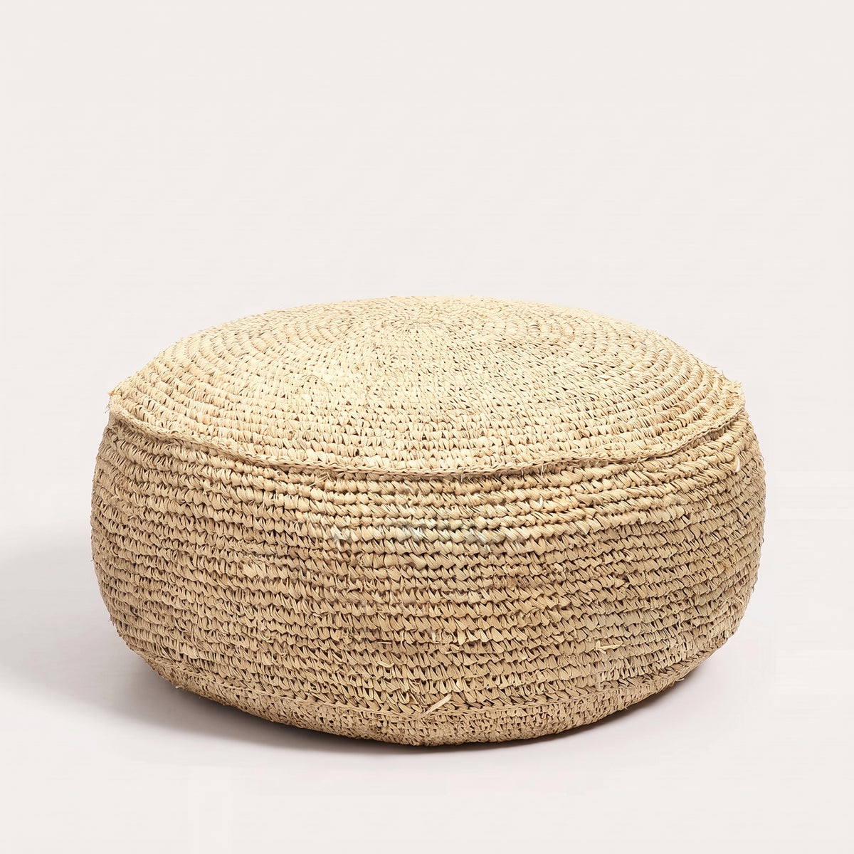 Pouf rond Flores en raphia naturel crocheté vu de face sur fond blanc