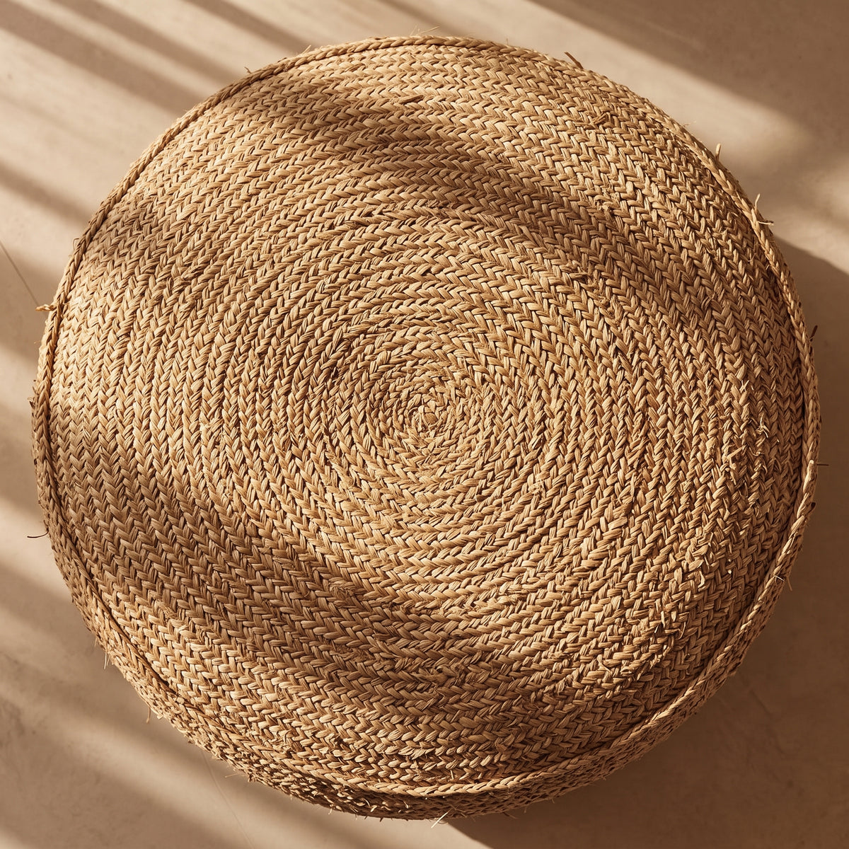 Dessus du pouf rond Flores en raphia crocheté, vu d'en haut avec son tressage en spirale