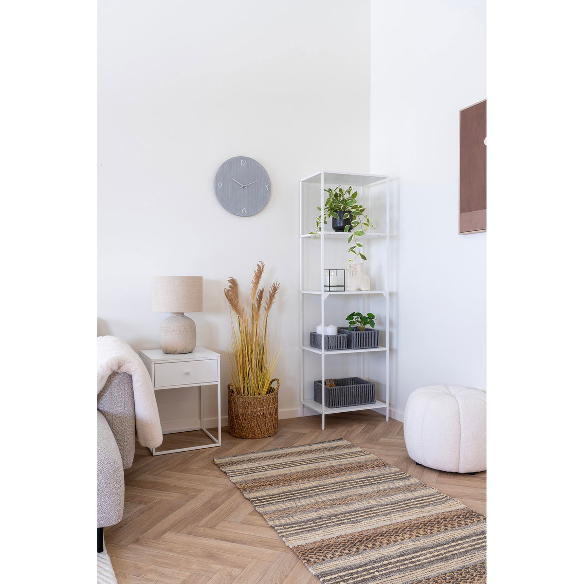 Pouf Paisley teddy blanc cassé dans un coin de pièce près d'une étagère blanche à montants fins et d'un tapis de couloir rayé
