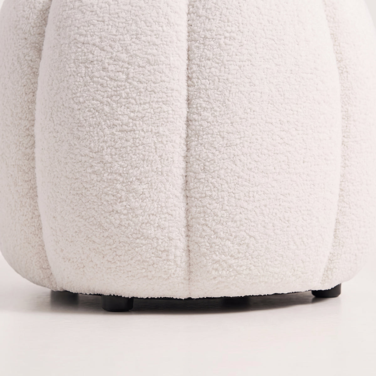 Détail des côtes cousues en teddy blanc cassé et des pieds noirs du pouf Paisley