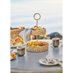Étagère Rifbjerg herbe de mer naturelle sur une table extérieure avec fruits et viennoiseries